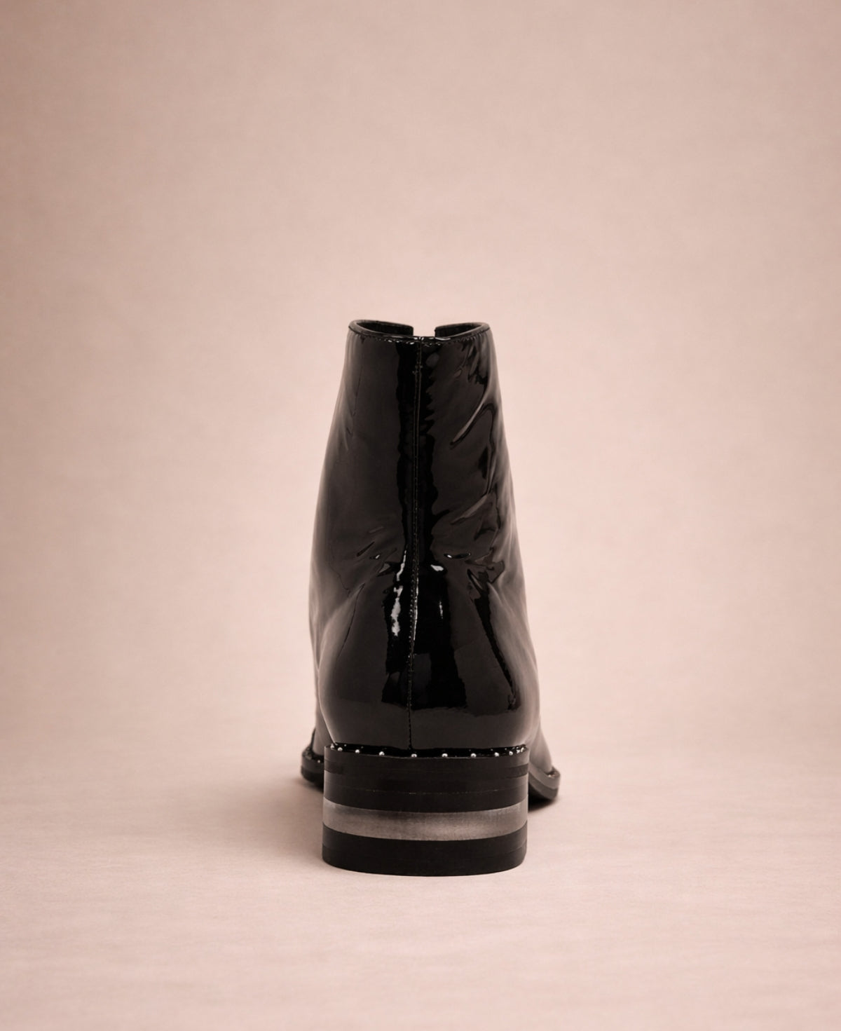 Black patent leather ankle boots back view highlighting heel and structure
