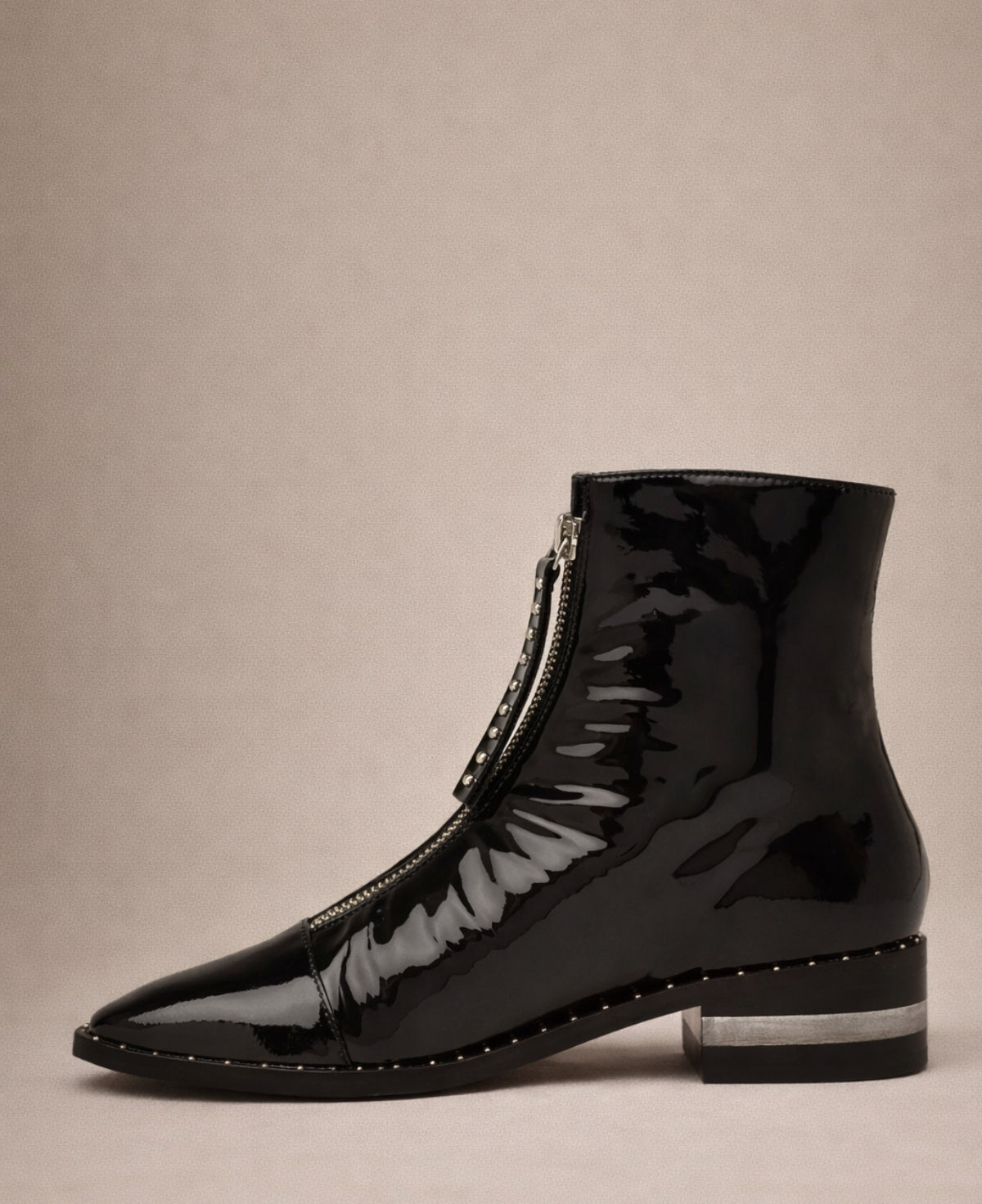 Black patent leather ankle boots inner side view showing front zip closure
