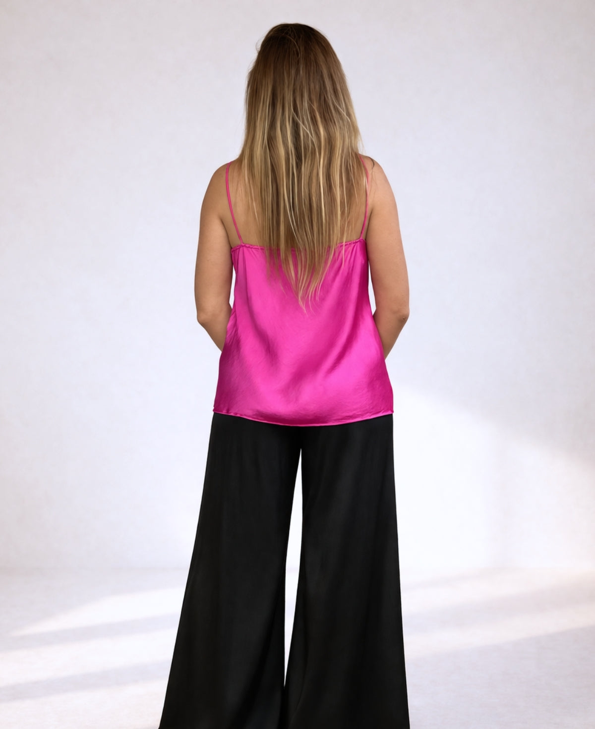 Back view of hot pink satin camisole showing lightweight fabric and relaxed fit