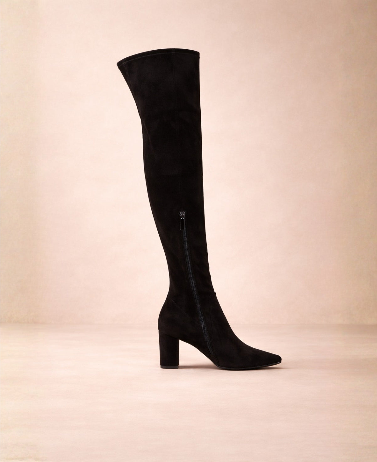 Black over-the-knee boots featuring inner side zip closure, slim fitted shaft and block heel in a soft neutral studio.