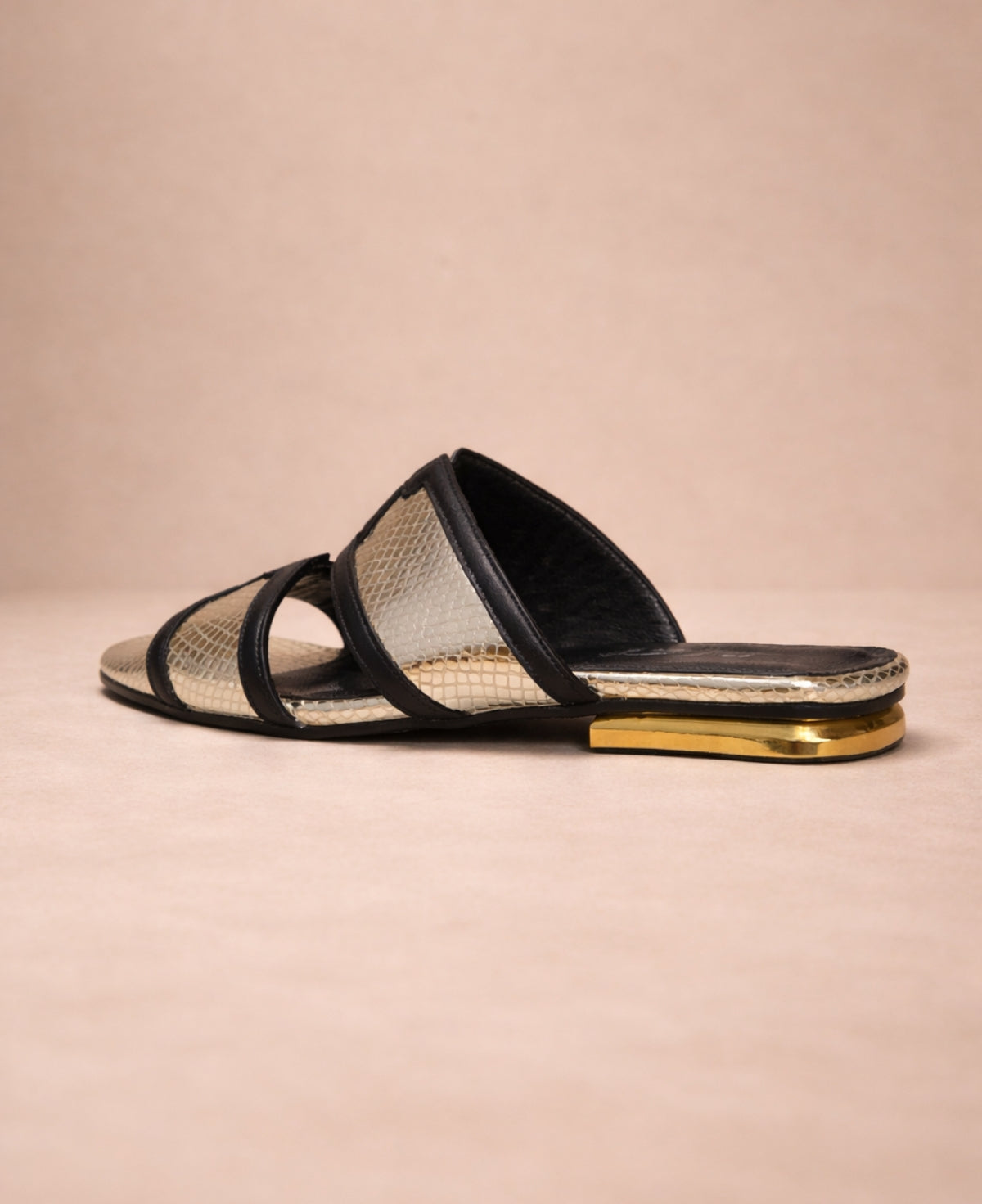 Close-up of metallic gold snakeskin slide sandals for women highlighting straps and metallic finish