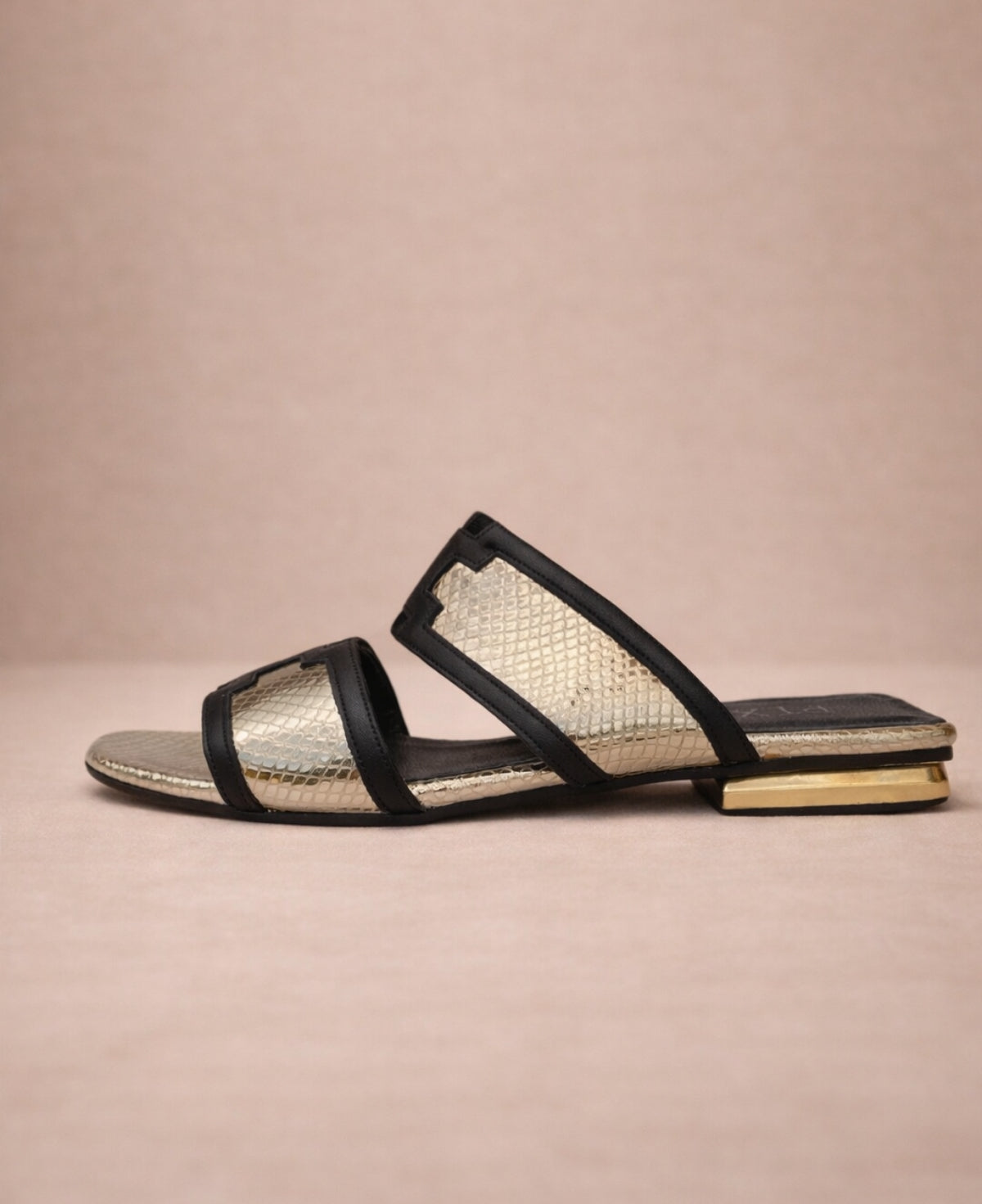 Side view of metallic gold snakeskin slide sandals for women with structured straps and gold heel detail