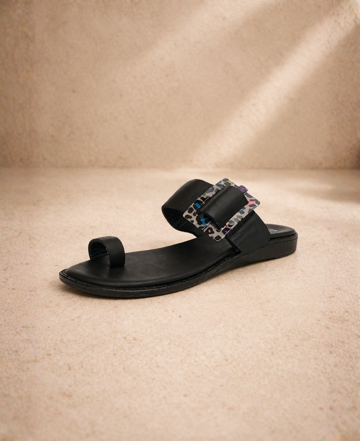 Black PIXY Shebah Slide sandal front angled view with wide strap and statement buckle detail