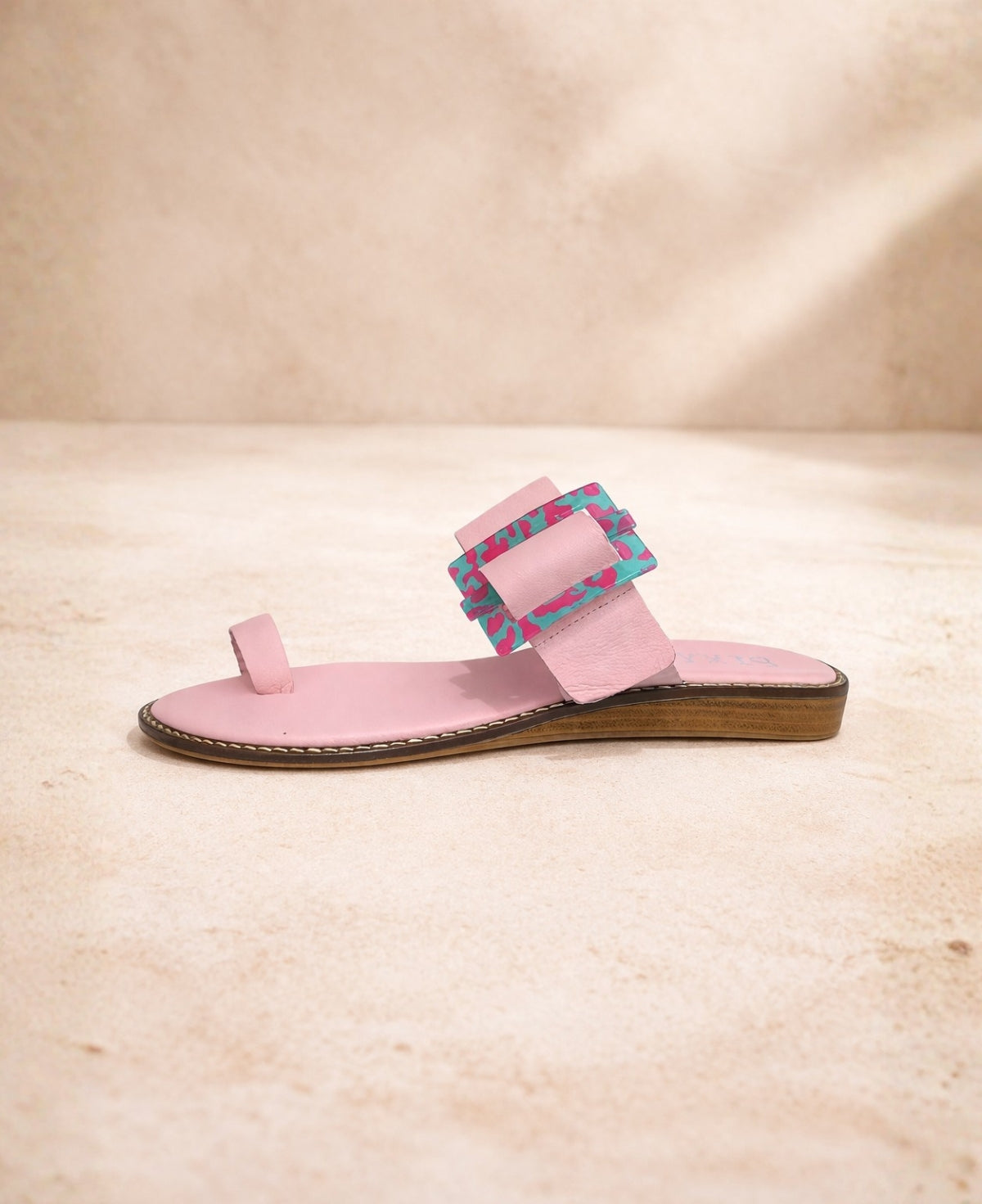 Pink leather slide sandal side profile with flat sole and toe loop detail