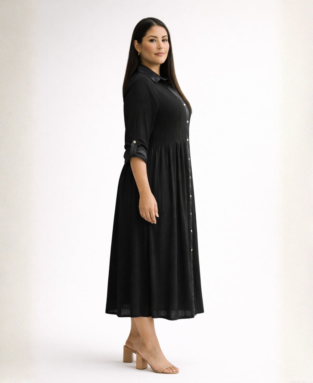 Side profile of black Roxberry Curvy Fit shirt dress showing raised waist seam, gathered skirt panel and structured winter weight crinkle fabric.