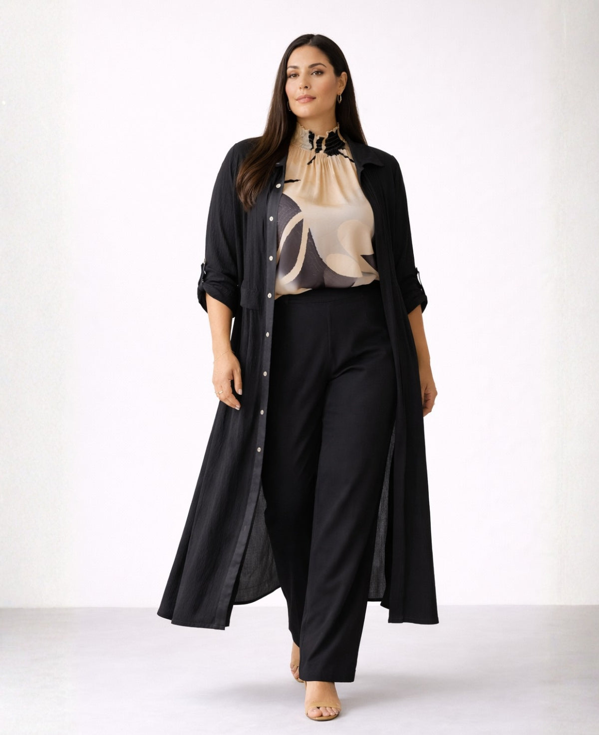 Black Roxberry Curvy Fit shirt dress worn open as duster over patterned blouse and black pants with visible satin placket and structured crinkle fabric.