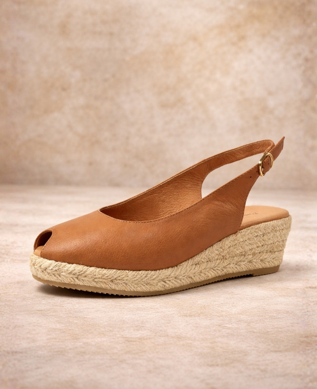 Angled front view of tan leather espadrille wedge sandal with peep toe and textured jute sole